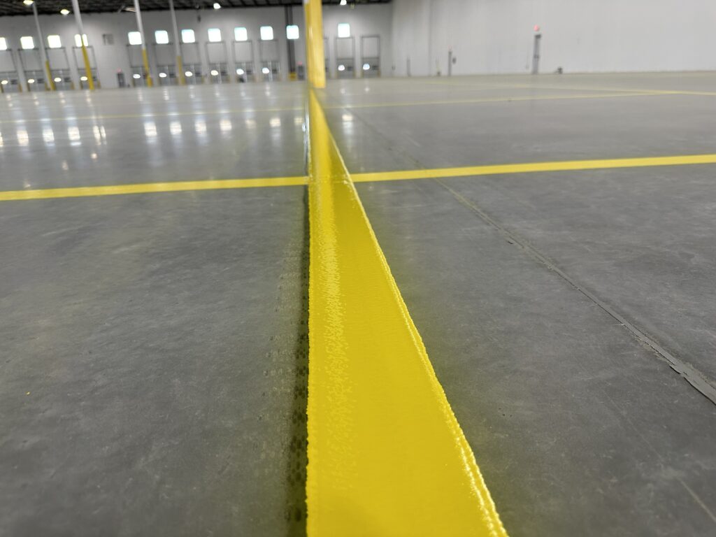 Epoxy warehouse striping with pedestrian walkways and staging zones in logistics facility