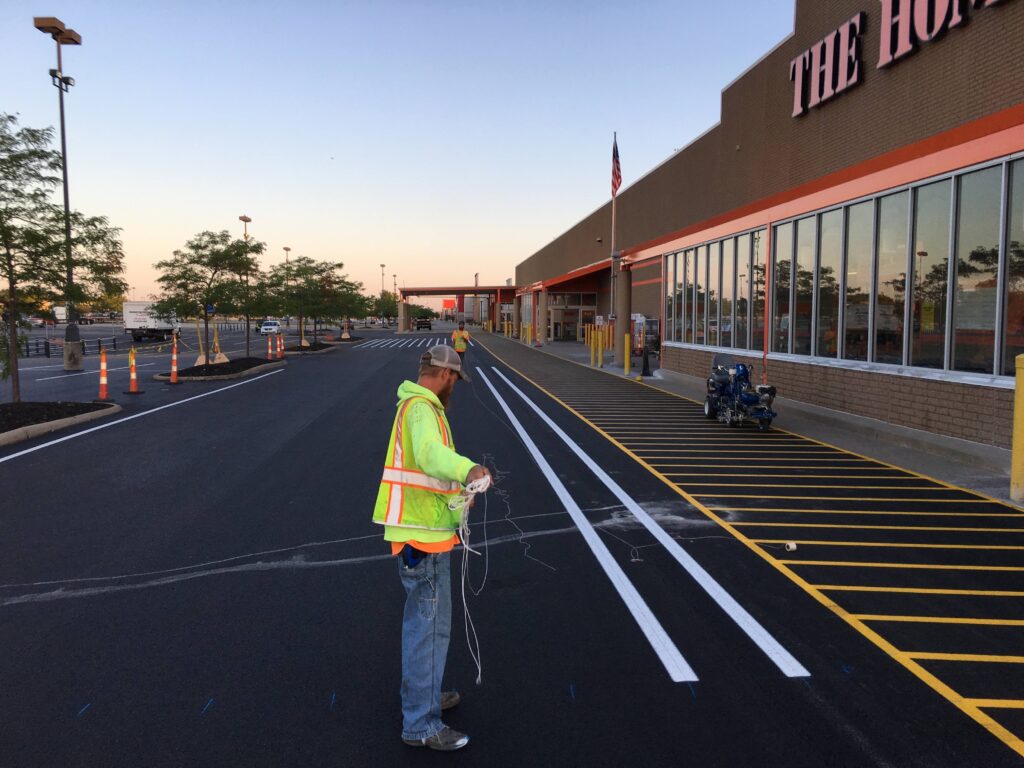 Fresh white traffic lines and yellow crosshatched no-parking area outside a Home Depot store