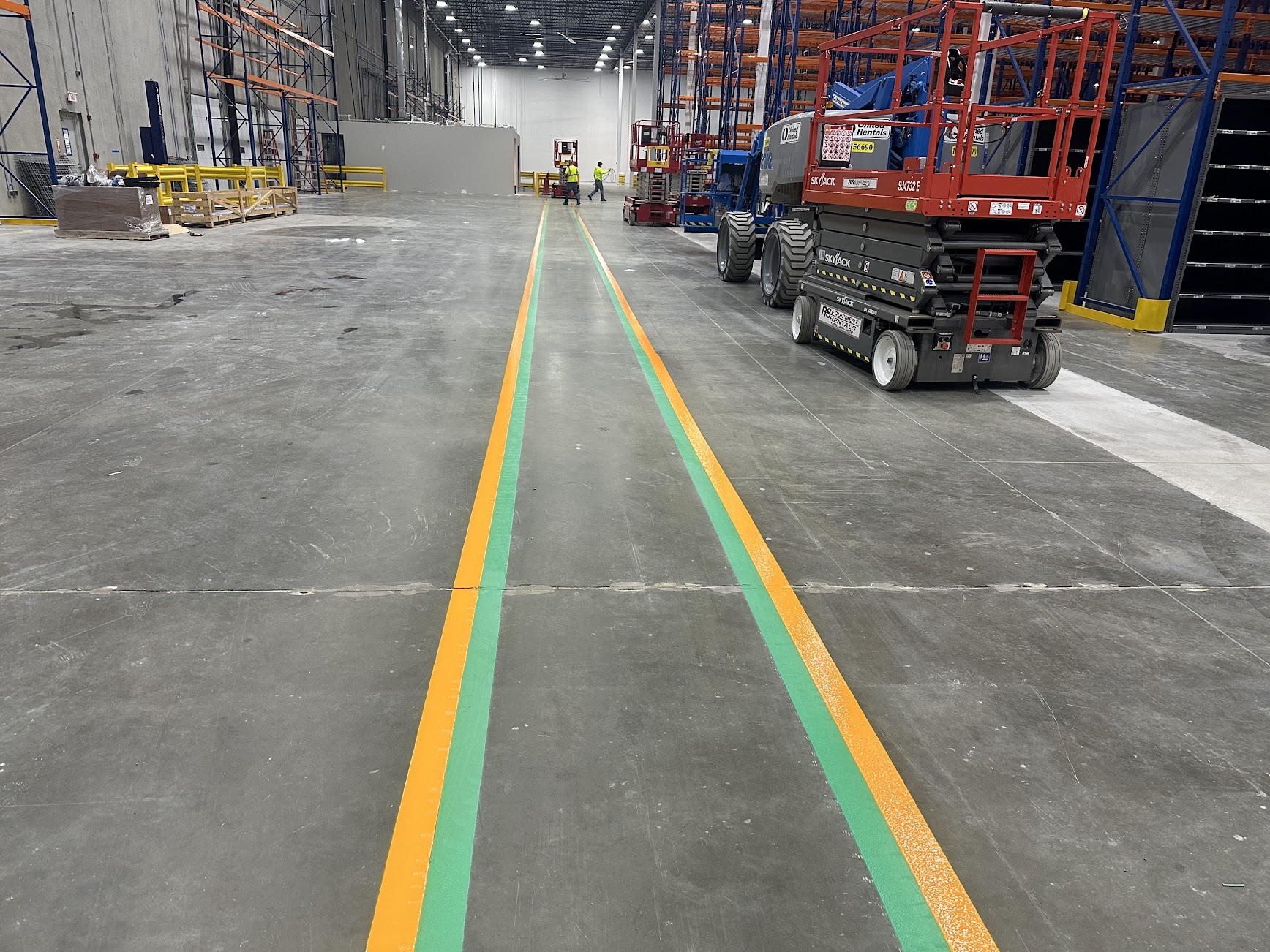 Orange and green floor lines defining warehouse traffic routes