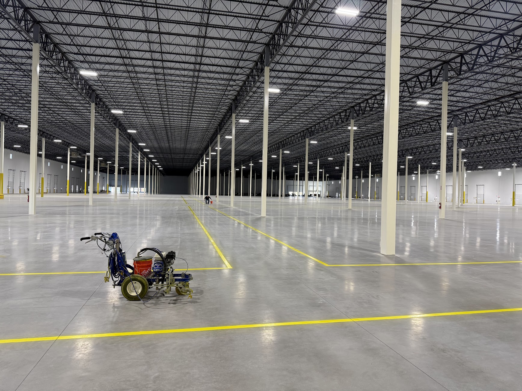 Warehouse interior with yellow floor routes and support columns