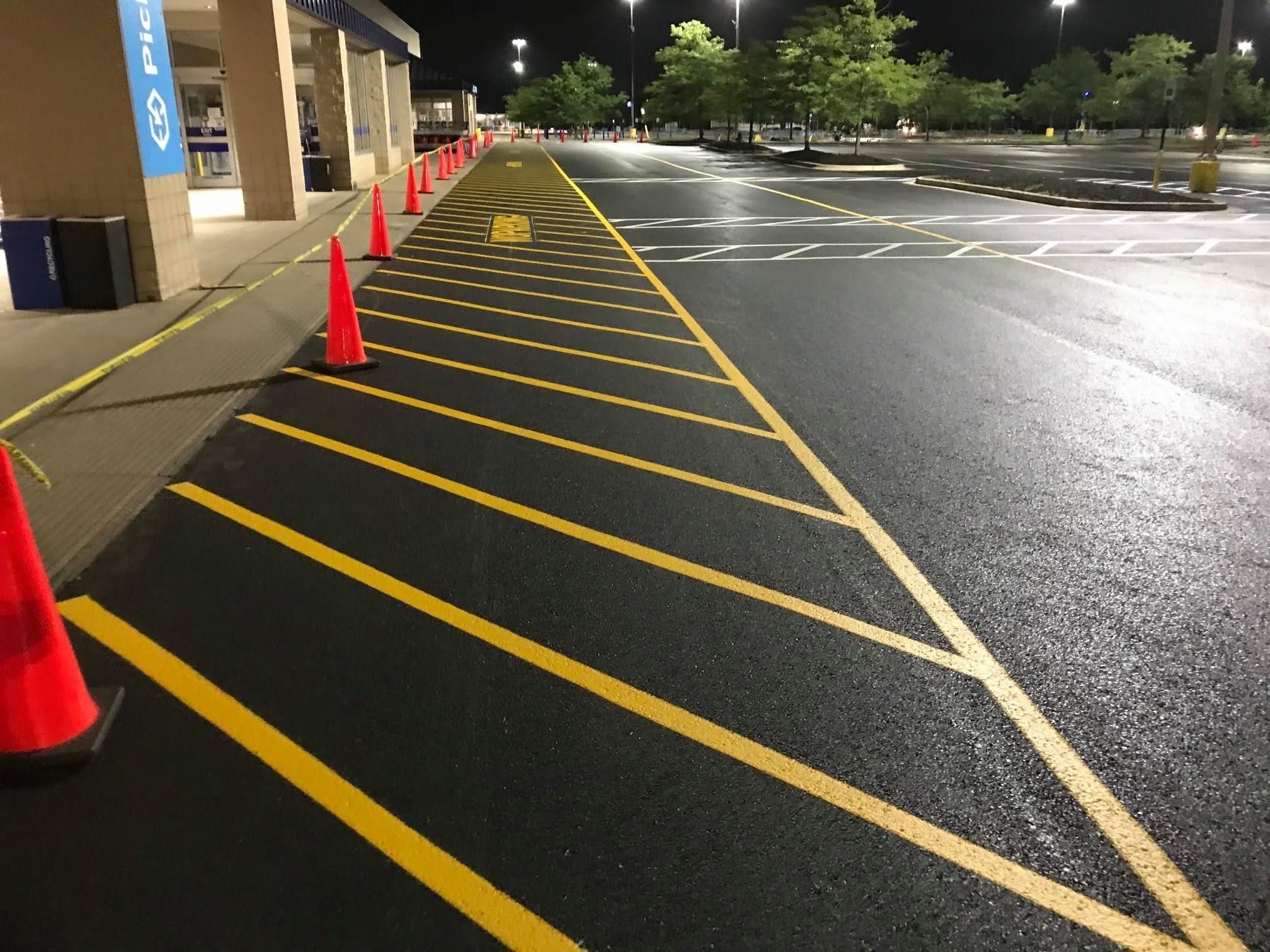 Fresh yellow hatch markings and white parking lines at night