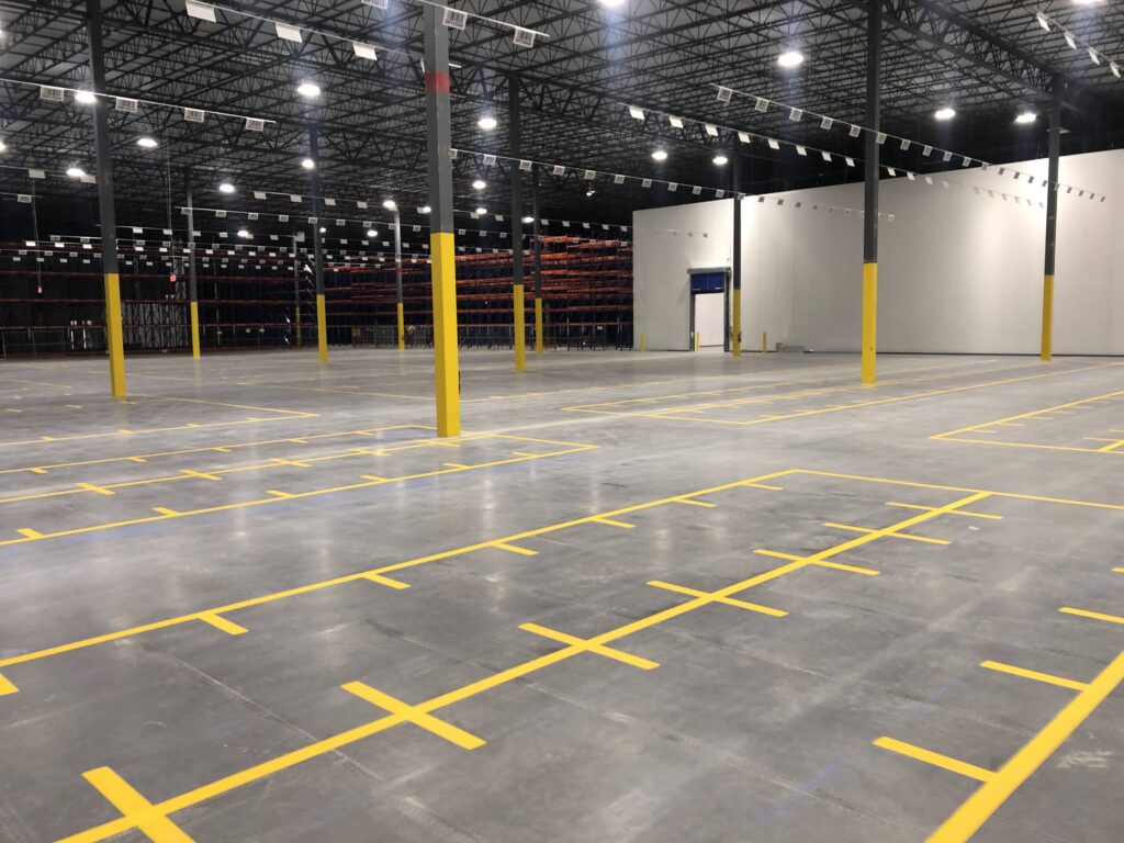 Yellow warehouse storage bay markings beside pallet racks