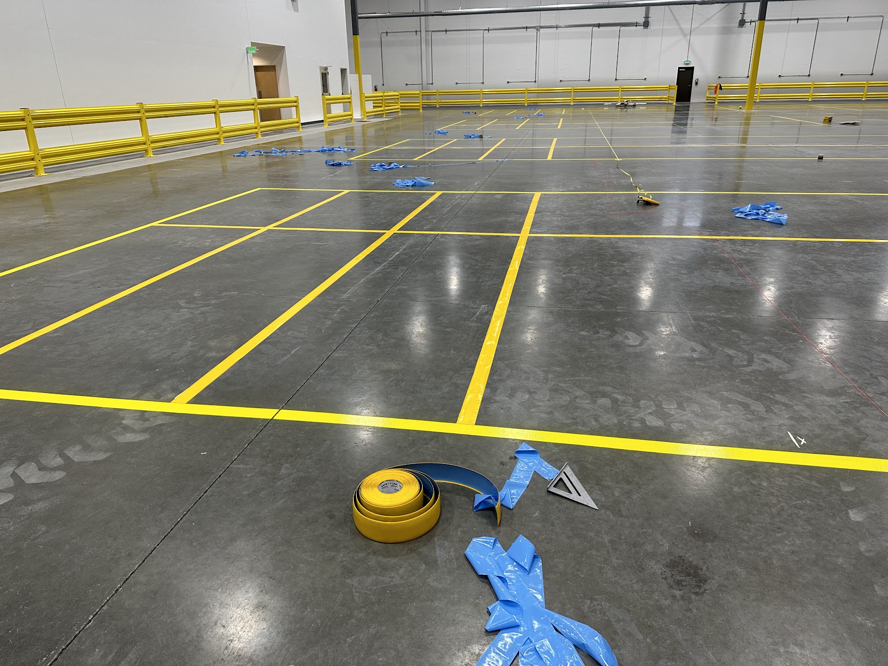 Yellow industrial floor tape layout installed inside warehouse